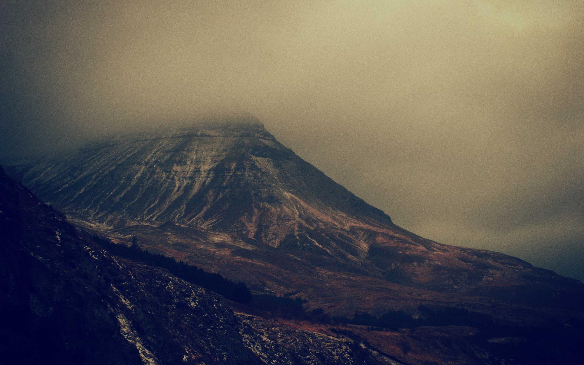 Dark volcanic massif under low cloud
