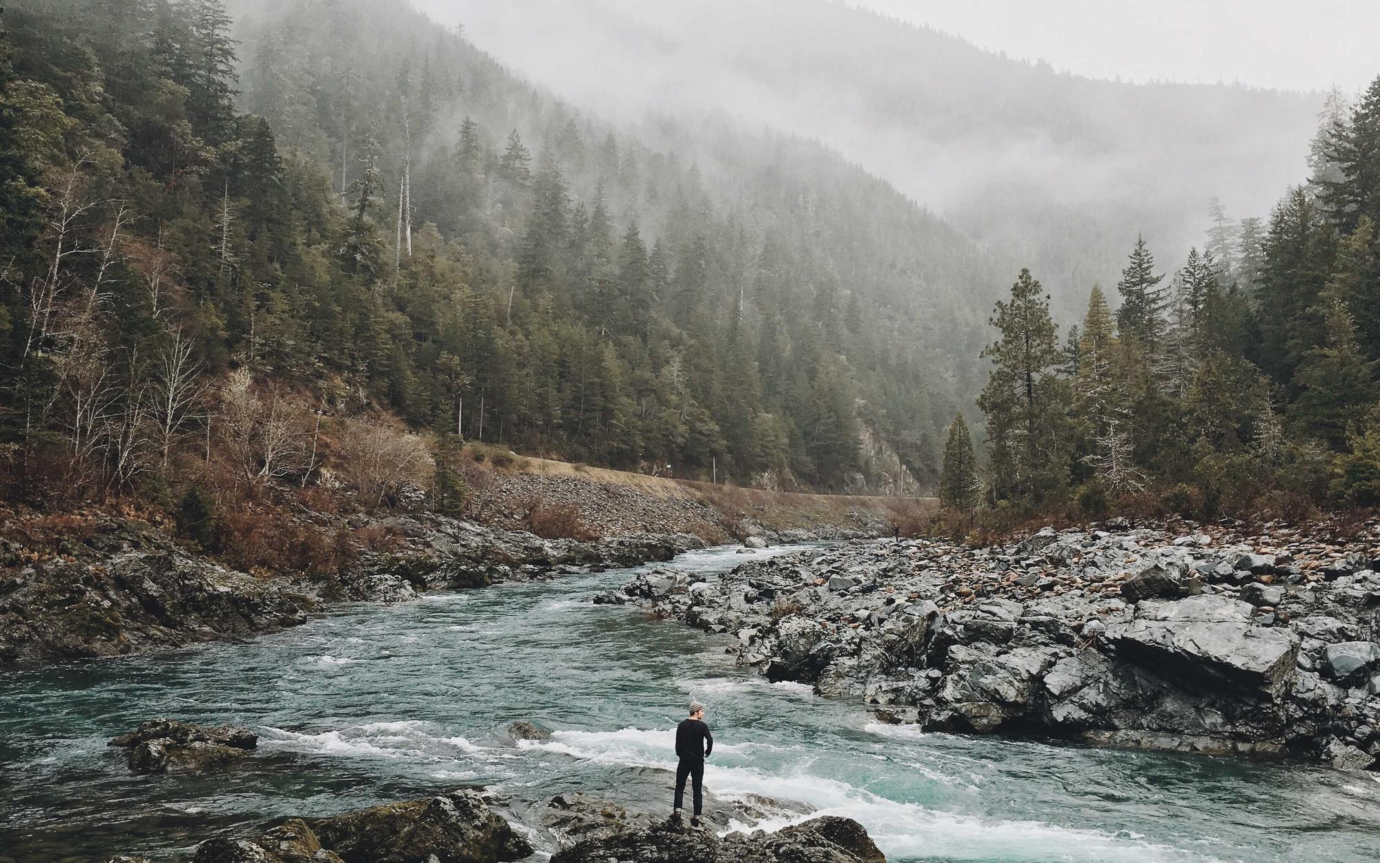 Lone figure standing in a river valley